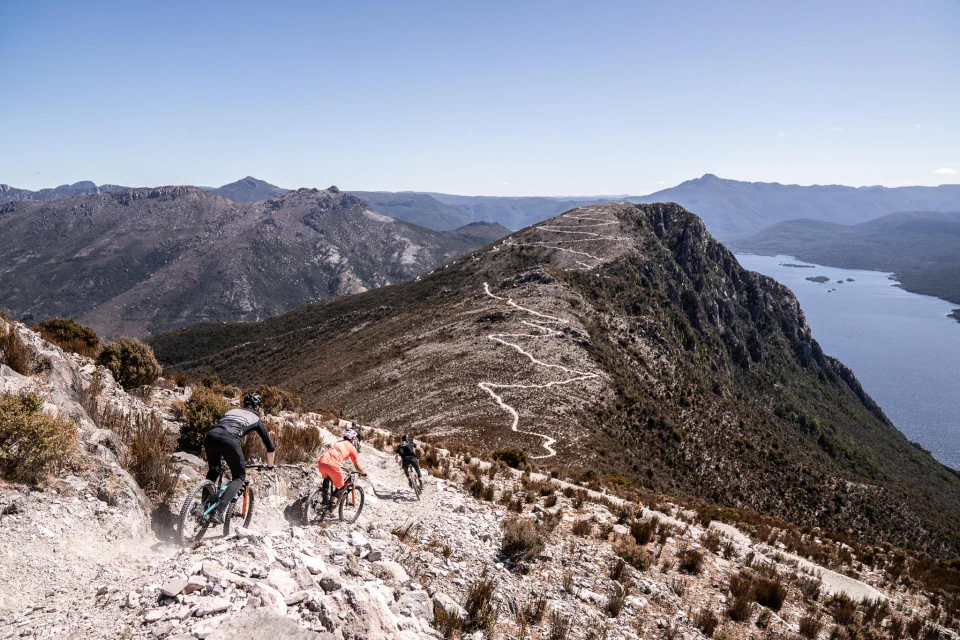 Mountain bikers descending a rocky Mt Owen trail above the lake